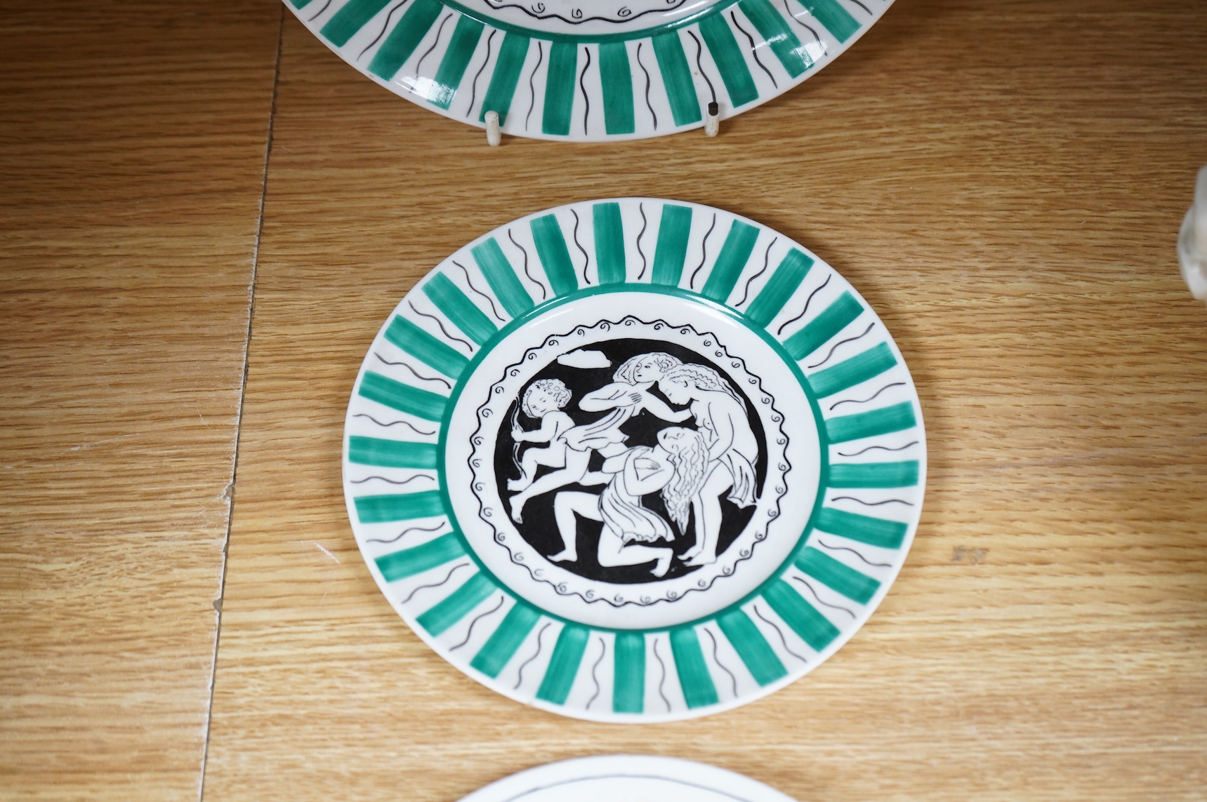 Laura Knight for Foley China cupid plate and matching side plate, together with a Graham Sutherland for Foley China plate and matching side plate, largest 23cm in diameter